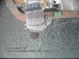 Overhead EM camera view of a salmon trolling vessel as a hooked salmon is brought alongside the rail on a trolling line above the water.