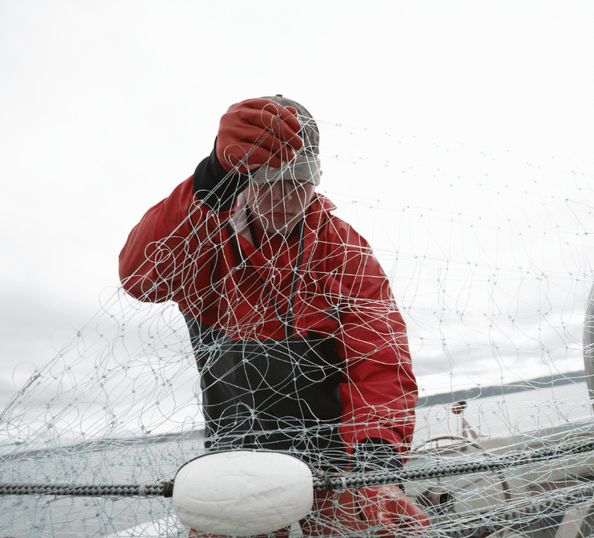 Fisher in red jacket inspecting gillnet lines and floats on deck